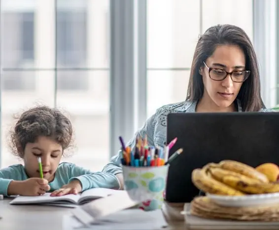 A working woman practicing work life balance next to her daughter.